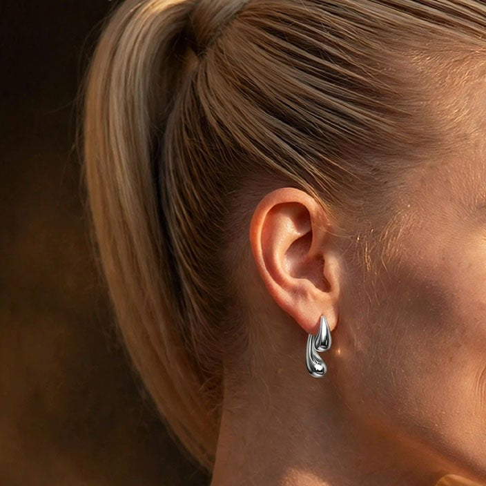 Model trägt Double Drop Tropfen-Ohrstecker aus Edelstahl in Silber